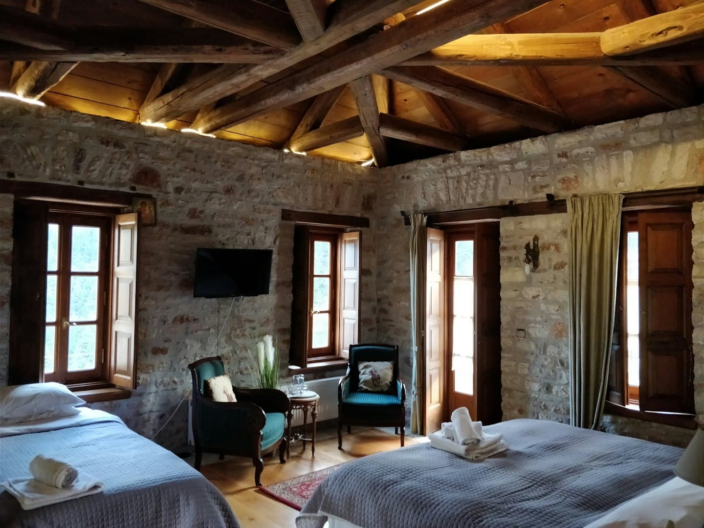 Camera da letto rustica con pareti in pietra e travi in legno.