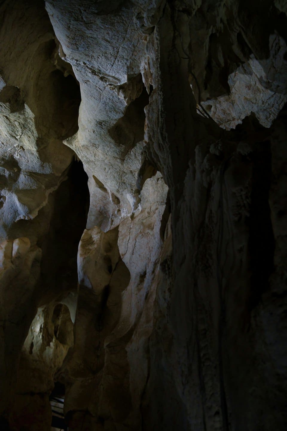 Formazioni rocciose frastagliate all'interno di una grotta naturale buia.